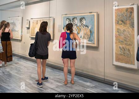 Museo di Creta, vista posteriore dei turisti che studiano l'antico affresco minoico intitolato Ladies in Blue, Museo Archeologico di Heraklion, Creta, Grecia Foto Stock