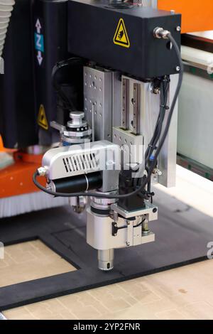 Taglio della gomma con macchina da taglio digitale CNC. Primo piano della taglierina a coltelli oscillanti CNC a superficie piana automatica. Messa a fuoco selettiva. Foto Stock