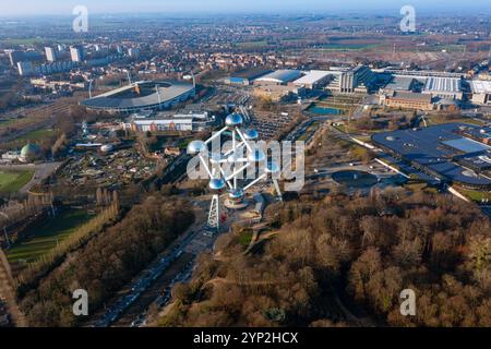 Vista aerea dell'Atomium di Bruxelles, circondato da vegetazione lussureggiante, architettura moderna e paesaggi urbani, che mettono in risalto l'iconico simbolo del Belgio Foto Stock