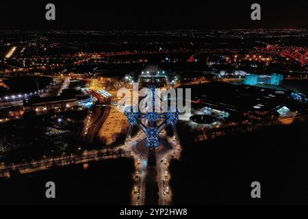 Affascinante vista aerea notturna dell'Atomium di Bruxelles, Belgio, illuminata contro lo skyline della città. Una perfetta miscela di architettura moderna e CA Foto Stock