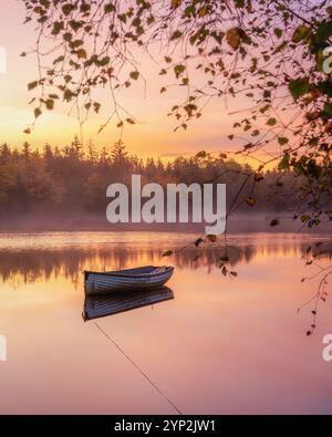 Barca solitaria che galleggia sul lago Loch Rusky all'alba, Highlands, Scozia, Regno Unito, Europa Foto Stock