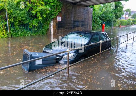 Strada allagata con bidone galleggiante bloccato davanti all'auto, Sutton Coldfield, Inghilterra, Regno Unito, Europa Foto Stock