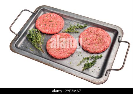 Hamburger crudo polpettine di carne tritata per hamburger con erbe su vassoio isolato su sfondo bianco. Foto Stock