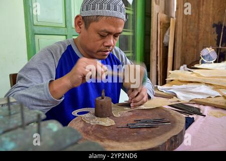 Laboratorio di burattini per il gioco d'ombra (wayang kulit), Bima Art Shadow Puppet Maker, Sondakan District, solo (Surakarta), Giava Island, Indonesia, Southea Foto Stock