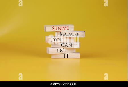 Sforzatevi perché potete farlo simbolo scritto su blocchi di legno con parole . Bellissimo sfondo giallo. Business e STRE. Copia spazio. Foto Stock