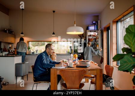 Libero professionista che prepara il documento mentre si siede al tavolo da pranzo Foto Stock