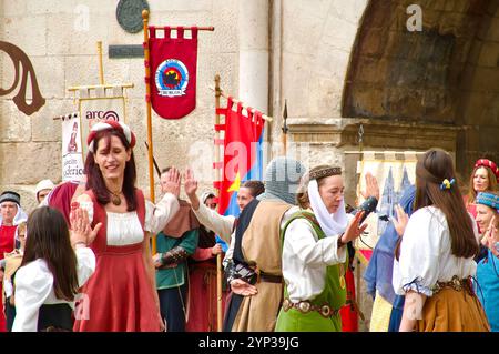 Partecipanti alle feste El Cid con costumi medievali che ballano di fronte all'Arco di Santa Maria, alle porte della città di Burgos Castiglia e León Spagna Europa Foto Stock