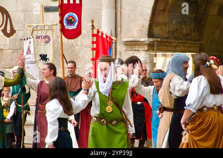 Partecipanti alle feste El Cid con costumi medievali che ballano di fronte all'Arco di Santa Maria, alle porte della città di Burgos Castiglia e León Spagna Europa Foto Stock