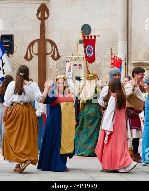 Partecipanti alle feste El Cid con costumi medievali che ballano di fronte all'Arco di Santa Maria, alle porte della città di Burgos Castiglia e León Spagna Europa Foto Stock