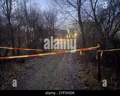 Vilnius, Lituania. 28 novembre 2024. La polizia lituana chiude la strada mentre gli investigatori e i servizi di emergenza lavorano sul luogo dell'incidente. Gli investigatori lituani stanno lavorando sulla base del presupposto che i dati del registratore dei dati di volo e del registratore vocale dell'aereo cargo precipitato dalla Germania possano essere letti nel prossimo futuro. Crediti: Alexander Welscher/dpa/Alamy Live News Foto Stock