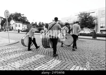 Batteristi che marciano per le strade acciottolate di Guimarães in monocromia Foto Stock