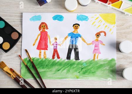 Disegno per bambini di una famiglia felice e provviste su un tavolo in legno, vista dall'alto Foto Stock