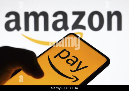 In questa immagine, il logo Amazon Pay visualizzato su uno smartphone e sullo sfondo il logo Amazon Foto Stock