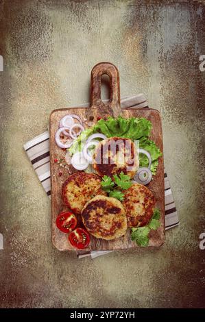 Cotolette di pollo fritte, pollo tritato, con verdure, su un tagliere, con insalata di verdure, vista dall'alto, fatti in casa, nessuno Foto Stock