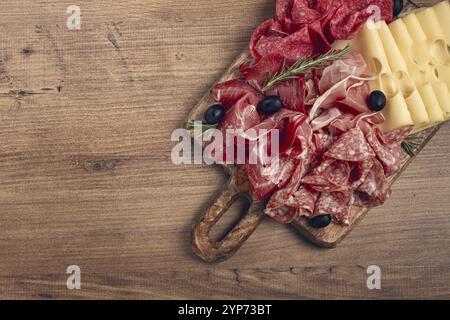 Carne assortita, antipasto, prosciutto, salame e prosciutto, con formaggio maasdam e olive, su una tavola di legno, colazione, vista dall'alto, vista ravvicinata, nessuno Foto Stock