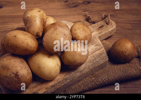 Patate crude, sparse su un tagliere, primo piano, nessuna gente Foto Stock
