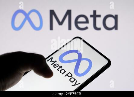 In questa immagine, il logo Meta Pay visualizzato su uno smartphone e sullo sfondo il logo Meta Platforms Foto Stock