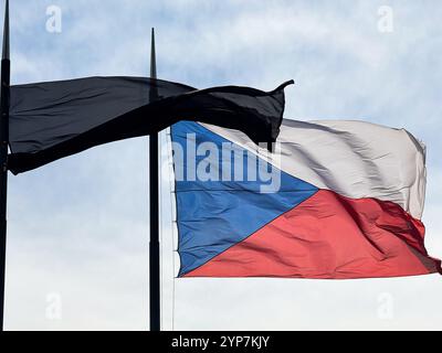 Karlstejn, repubblica Ceca - 19 maggio 2024. Bandiera ceca e bandiera in lutto nera che si muovono in vento nel castello di Karlstejn Foto Stock