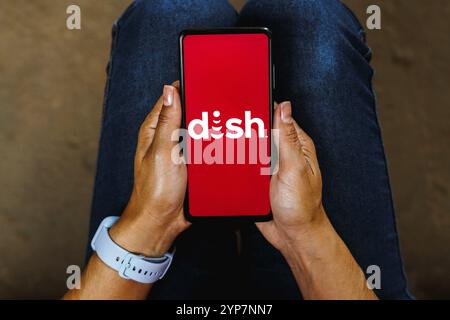 In questa immagine, il logo Dish Network Corporation viene visualizzato sullo schermo di uno smartphone Foto Stock