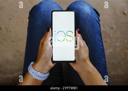 In questa immagine, il logo iOS viene visualizzato sullo schermo di uno smartphone Foto Stock