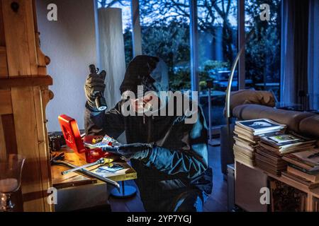 Symbolbild Wohnungseinbruch, Täter ist von der Gartenseite Her, in eine Wohnung eingedrungen und sucht nach Beute, bricht eine Geldkassette auf, findet Wertgegenstände, Geld, Einbrecher *** immagine simbolica del furto, l'esecutore ha rotto in un appartamento dal lato del giardino e sta cercando bottino, rompe apre una cassa, trova oggetti di valore, denaro Foto Stock