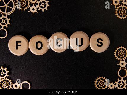 I blocchi di legno mostrano la parola focus in rosso vivace, ambientato contro un modello cerebrale realistico, che simboleggia la salute cognitiva e la concentrazione. Foto Stock