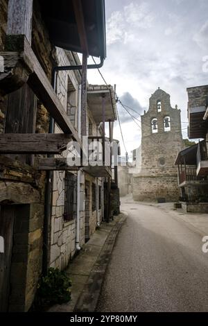 Case in pietra che costeggiano una stretta strada che porta alla chiesa nel villaggio rurale spagnolo Foto Stock