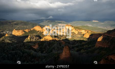 Las médulas antiche miniere d'oro romane che brillano sotto il cielo nuvoloso e un arcobaleno all'alba Foto Stock