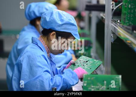 FUYANG, CINA - 29 NOVEMBRE 2024 - i lavoratori si preparano a imballare un controller dopo l'ispezione finale presso l'officina DIP di Anhui Shixin Electronic Technol Foto Stock