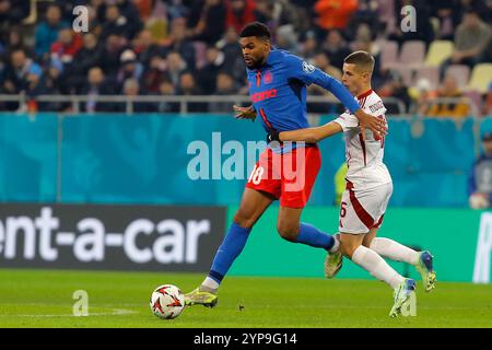 Bucarest, Romania. 28 novembre 2024. Il Malcom Edjouma (L) della FCSB sfida con Christos Mouzakitis dell'Olympiakos durante la partita di campionato tra FCSB e Olympiakos alla partita di calcio UEFA Europa League allo stadio Arena Nationala di Bucarest, Romania, 28 novembre 2024. Crediti: Cristian Cristel/Xinhua/Alamy Live News Foto Stock