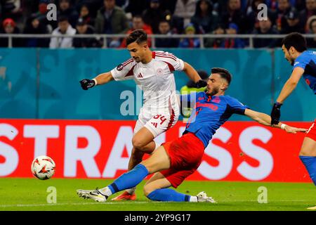 Bucarest, Romania. 28 novembre 2024. Mihai Popescu (R) della FCSB affronta il Charalampos Kostoulas dell'Olympiacos durante la partita di campionato tra FCSB e Olympiacos alla partita di calcio UEFA Europa League allo stadio Arena Nationala di Bucarest, Romania, 28 novembre 2024. Crediti: Cristian Cristel/Xinhua/Alamy Live News Foto Stock