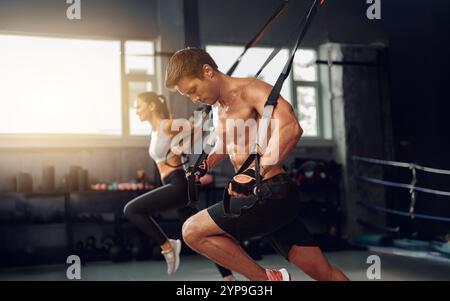 Allenamento dinamico ed efficace con allenamento delle sospensioni in un ambiente moderno di palestra Foto Stock