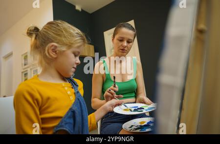 L'insegnante in officina ha messo in tecnica due ragazze come assemblare un mosaico termico Foto Stock