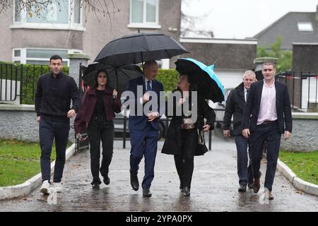 Tanaiste e Fianna Fail leader Micheal Martin, accompagnato dalla sua famiglia, vota alla St Anthony's Boys' School, Beechwood Park, Ballinlough, Cork, mentre gli elettori si recano alle elezioni generali del 2024 in Irlanda. Data foto: Venerdì 29 novembre 2024. Foto Stock