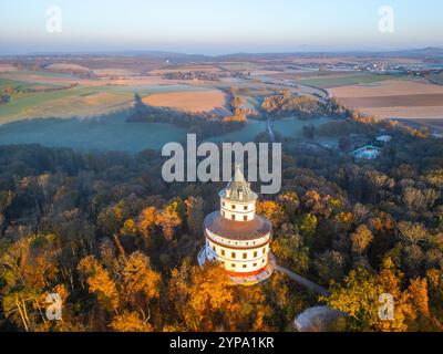 Il castello barocco di Humprecht si erge elegantemente sopra Sobotka, circondato da un vivace fogliame autunnale mentre sorge il sole, illuminando il paesaggio con un caldo bagliore. Foto Stock