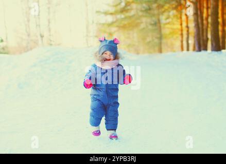 Inverno felice bambino sorridente che si diverte sulla neve Foto Stock