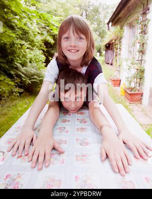 Due ragazzi, entrambi di 9 anni, che ingannano all'aperto. Foto Stock