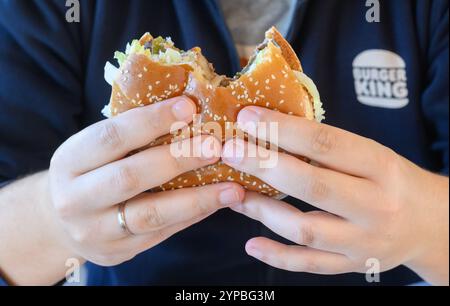 Hannover, Germania. 29 novembre 2024. ILLUSTRAZIONE - Un uomo mangia un Burger Whopper in un ristorante della catena di fast food Burger King. Credito: Julian Stratenschulte/dpa/Alamy Live News Foto Stock