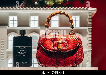 Cannes, Francia - 10 novembre 2024: L'iconica borsa in pelle di serpente Gucci Bamboo e il profumo Gucci Guilty esposti in una vetrina del ballo della Croisette Foto Stock