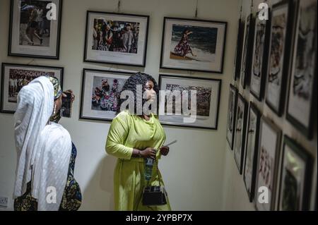 Abuja, Nigeria. 28 novembre 2024. Le persone visitano una mostra fotografica tenuta dalla Xinhua News Agency presso il China Culture Center di Abuja, Nigeria, 28 novembre 2024. All'apertura di una mostra fotografica di Xinhua giovedì, i visitatori hanno elogiato le foto di notizie che mostrano lo sviluppo della Cina nel corso degli anni. A tema "Lens of Xinhua: Images of the Century", la mostra è stata organizzata dall'ufficio di Abuja di Xinhua. Presentava immagini iconiche che evidenziavano le pietre miliari dell'evoluzione economica, sociale e culturale della Cina attraverso frammenti di ricordi nazionali e collettivi. Crediti: Wang Guansen/Xinhua/Alamy Live News Foto Stock