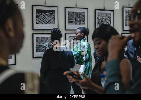 Abuja, Nigeria. 28 novembre 2024. Le persone visitano una mostra fotografica tenuta dalla Xinhua News Agency presso il China Culture Center di Abuja, Nigeria, 28 novembre 2024. All'apertura di una mostra fotografica di Xinhua giovedì, i visitatori hanno elogiato le foto di notizie che mostrano lo sviluppo della Cina nel corso degli anni. A tema "Lens of Xinhua: Images of the Century", la mostra è stata organizzata dall'ufficio di Abuja di Xinhua. Presentava immagini iconiche che evidenziavano le pietre miliari dell'evoluzione economica, sociale e culturale della Cina attraverso frammenti di ricordi nazionali e collettivi. Crediti: Wang Guansen/Xinhua/Alamy Live News Foto Stock