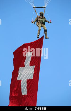 Ein Fallschirmaufklärer der Schweizer Armee an einem Freifallschirm. Er trägt die Schweizer Nationalflagge mit sich. Hochkant. Die Flugshow ZigAirMeet mit internationaler Beteiligung aus dem militärischen und zivilen Luftfahrtbereich fand AM 18. und 19. Agosto 2023 a Mollis, Kanton Glarus, Schweiz, statt. Mollis Glarus Schweiz *** paracadutista dell'esercito svizzero su un paracadutista a caduta libera che porta la bandiera nazionale svizzera sul bordo della manifestazione aerea ZigAirMeet con la partecipazione internazionale del settore dell'aviazione civile e militare si è svolta il 18 e 19 agosto 2023 a Mollis, Canton Glarus, Svizzera Foto Stock