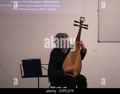 Praga, Repubblica Ceca. 28 novembre 2024. Un uomo suona la pipa tradizionale dello strumento musicale cinese durante un evento sulla medicina tradizionale cinese (TCM) a Praga, nella Repubblica Ceca, il 28 novembre 2024. L'evento sulla medicina tradizionale cinese (TCM) si è tenuto qui giovedì per promuovere il benessere e lo scambio culturale, mentre celebrava il 75° anniversario dell'instaurazione di relazioni diplomatiche tra Cina e Repubblica Ceca. Crediti: Dana Kesnerova/Xinhua/Alamy Live News Foto Stock