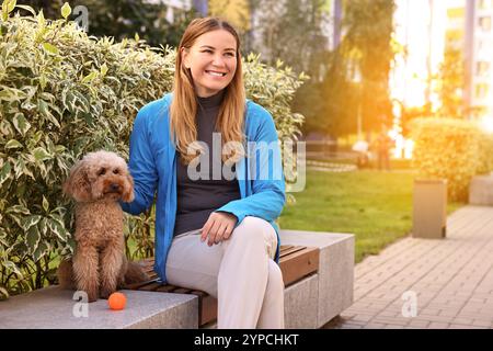 Donna con un simpatico cane Toy Poodle all'aperto Foto Stock