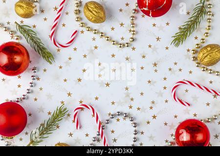 Cornice realizzata con decorazioni natalizie, rami di abete, baubles, noci su sfondo bianco con stelle dorate, stanza delle copie Foto Stock