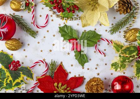 Decorazioni natalizie, come rami di abete, baubles, noci, poinsettia su sfondo bianco con stelle dorate, a grandezza naturale Foto Stock