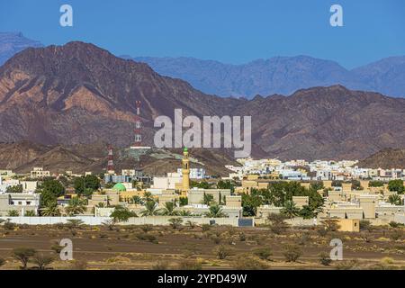 Il nuovo insediamento di Jabrin, vista dalla fortezza del palazzo di Jabrin, dietro le montagne di Jebel Akhdar, vicino alla città di Bahla, penisola arabica Foto Stock