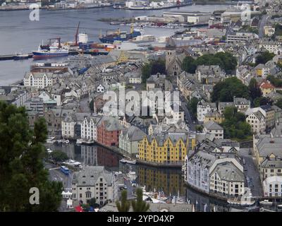 Vista urbana con edifici colorati lungo l'acqua e molte barche, alesund, norvegia Foto Stock