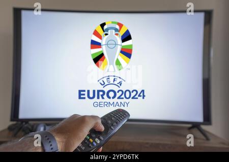 20 maggio 2024, Brasile. In questa immagine, una mano che tiene in mano un telecomando TV davanti al Campionato europeo di calcio UEFA (Euro 2024 GE Foto Stock