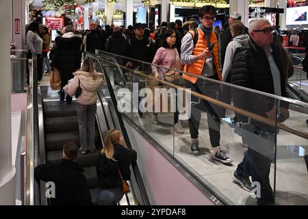 Le persone fanno acquisti presso il flagship store di Macy's Herald Square il 29 novembre 2024 a New York. Foto Stock